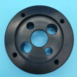 Custom machined black plastic flange plate with complex center cutout